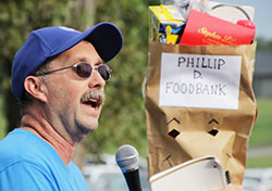 John Payne, left, manager of Evansville's St. Vincent de Paul Thrift Store, stands next to the Mascot for the annual Walk for the Poor, Phillip D. Foodbank. Photo by Tim Lilley.