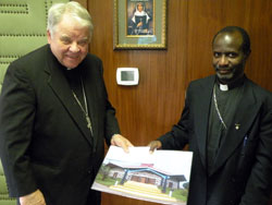 Bishop John M. D’Arcy presents a check to Bishop Robert Mihiirwa of Fort Portal, Uganda, at the Fort Wayne chancery Sept. 15. A portion of funds from the Zeiger endowment was used to pay for costs of the roof construction to the Vikara Cathedral in Fort Portal. Part of the Zeiger endowment is utilized for overseas mission activity.