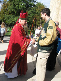 Bishop D’Arcy shakes hands with Michael Agrippina, a high school junior from Atlanta, who was visiting the University of Notre Dame and attended the Red Mass for law students, attorneys and political officials.