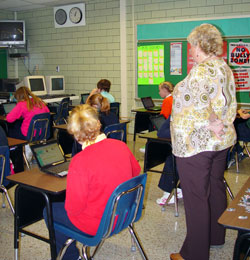 Sts. Peter and Paul teacher Katrina Martin watches as fifth graders solve math problems using their Netbooks. (Message photo by Mary Ann Hughes)