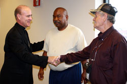 Bishop Kevin C. Rhoades chats with residents Danny Forrest and John Peepers before a Memorial Day gathering at South Bend’s Center for the Homeless.