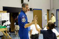 Astronaut Col. Michael Good high-fives a student after an assembly at Queen of Angels School where he presented a talk on his space travels on Sept. 17.