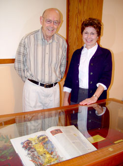Myles Towne and pastoral associate Lynda Provence stand behind a display which includes Myles’ reproduction of “The Saint John's Bible” which is on display during Lent at St. John the Baptist Church in Newburgh. (Message photo by Mary Ann Hughes)