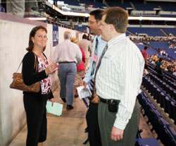 Julie Carr, a member of St. Malachy Parish in Brownsburg, gets assistance from volunteers Christopher Breen and Michael Hussey before the start of the 175th anniversary Mass at Lucas Oil Stadium in Indianapolis on May 3. Breen and Hussey are also members of St. Malachy Parish in Brownsburg. (Photo by Mike Krokos) 