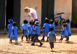 Erica Heinekamp, a member of St. John the Evangelist Parish in Indianapolis, leads children back to their classroom at a parish school in Haiti after they came outside to see her. The fourth-grade teacher at St. Susanna School in Plainfield has taken two mission trips to Haiti that have enriched her faith. (Submitted photo)