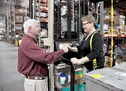 Bill Grote, left, chats on May 13, 2013, with Debbie Randall in a Grote Industries factory in Madison. Grote is chairman of the board of the family-owned business. (File photo by Sean Gallagher)