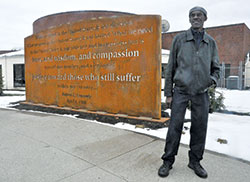 Abie Robinson, senior program coordinator for Indianapolis Parks and Recreation, stands on March 26 before a new memorial in Kennedy King Park in Indianapolis. The memorial pays tribute to a speech given by Robert F. Kennedy in the park on April 4, 1968, the day Rev. Martin Luther King Jr., was assassinated. Robinson attended the speech. (Photo by Sean Gallagher)