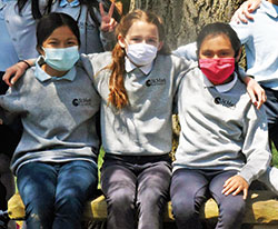 Quinn McGill, center, sits arm in arm with her friends and classmates Christina San, left, and Kaelynn De la Cruz on May 10 at St. Mark the Evangelist School in Indianapolis. Quinn, a fourth-grader at St. Mark, asked Indianapolis Mayor Joseph Hogsett to declare May 10 as “Be a Friend Day,” which the mayor did. (Photo by Sean Gallagher)