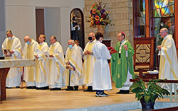 Archbishop Charles C. Thompson serves as principal celebrant at the Miter Society Mass in St. Mary-of-the-Knobs Church in Floyd County on Oct. 21. Concelebrating with him are Fathers William Marks, left, William Ernst, Anthony Hollowell, Stephen Banet, Daniel Atkins, Wilfred “Sonny” Day and Msgr. William F. Stumpf. Altar server Garrett Jennings holds the missal for the archbishop. (Submitted photo by Leslie Lynch)