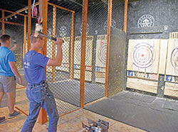 Seminarian Isaac Siefker, a member of St. John the Apostle Parish in Bloomington, throws an axe on Aug. 9 during an outing of archdiocesan seminarians to Anarchy Axe Throwing in Indianapolis. The outing was part of the annual convocation of archdiocesan seminarians. (Photo by Sean Gallagher)