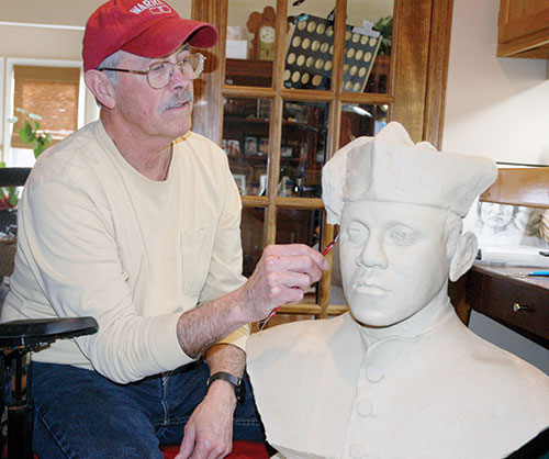 Forrest Tucker uses a sculpting knife to trim a clay bust of Venerable Augustus Tolton, the first recognized priest of African descent in the United States. (Photo by John Shaughnessy)