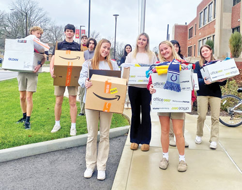 Samantha Manley, center, and other members of the National Honor Society at Father Thomas Scecina Memorial High School in Indianapolis show the bounty of clothing they collected for refugees being served by Catholic Charities Indianapolis. (Submitted photo)