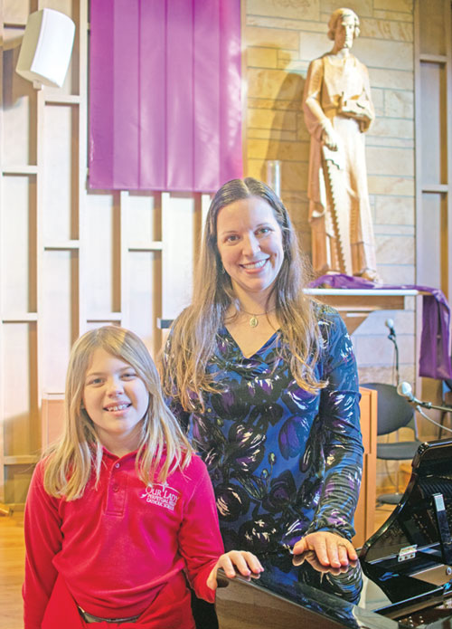 As a second-grade student at Our Lady of Perpetual Help Parish in New Albany, Emma Brose wrote a song praising Jesus, getting help with the sheet music for the song from Katelyn Stumler, director of liturgical music for the parish. (Submitted photo)