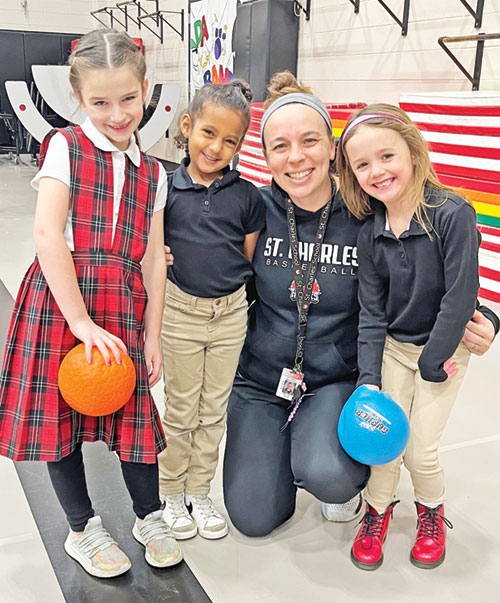 Kristin Mitchell, the middle school coordinator and teacher of health and physical education at St. Charles Borromeo School in Bloomington, shares a moment of joy with students Evelyn Glant, left, Enedina Kassamanian and Lucy Laughlin. (Submitted photo)