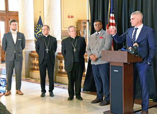 Rep. Bob Morris (R-Fort Wayne), right, addresses the media at a Feb. 3 press conference at the Indiana Statehouse in Indianapolis calling for repeal of the death penalty in the state. He was joined by Alexander Mingus, left, executive director of the Indiana Catholic Conference; Archbishop Charles C. Thompson of Indianapolis; Bishop Robert J. McClory of the Diocese of Gary, Ind.; and Demetrius Minor, national manager of Conservatives Concerned About the Death Penalty. (Photo by Sean Gallagher)