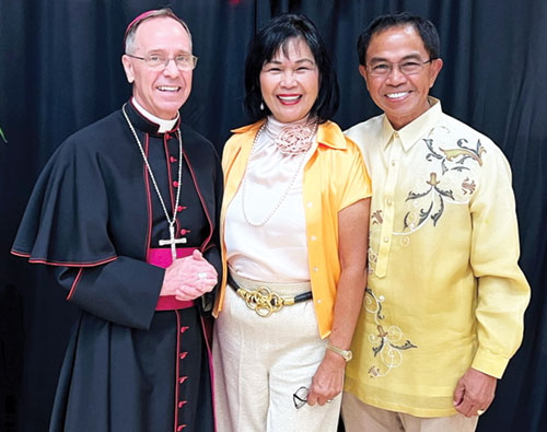 Photo at right: Sylvia, middle, and Primo Andres, members of St. Margaret Mary Parish in Terre Haute, pose with Archbishop Charles C. Thompson during a reception in the Archbishop Edward T. O’Meara Catholic Center in Indianapolis after the archdiocese’s 40th annual Wedding Anniversary Mass on Aug. 25, 2024. (Submitted photo)