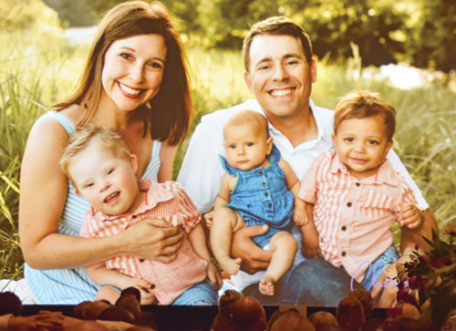 A photo of the Cochran family—Alyssa, left, Oliver, Hazel May, Cory and Atticus—is displayed during a gala for St. Elizabeth Catholic Charities in New Albany on April 10. Alyssa and Cory, who adopted Atticus through the agency’s Adoption Bridges of Kentuckiana, spoke at the event. (Photo by Natalie Hoefer) 