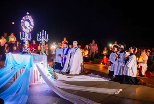 Father Michael Keucher, archdiocesan director of vocations, leads nighttime eucharistic adoration at Camp Rancho Framasa on Sept. 13 in Brown County during the annual family camp hosted by the archdiocesan Hispanic Ministry. (Submitted photo)
