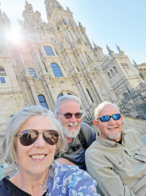Lisa Gray, left, Tony Schroeder and John Gray, members of Prince of Peace Parish in Madison, flash smiles in front of the Cathedral of Santiago de Compostela in Spain after completing their 500-mile journey on the Camino last spring. (Submitted photo)