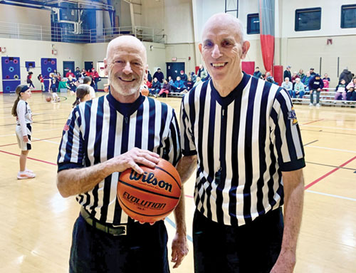 For Bill Wells, right, connections with other officials, players and coaches have led him to continue being a referee for the Catholic Youth Organization for about 25 years. Here, he shares the court with a longtime friend and fellow referee Tim Quigley. (Photo by John Shaughnessy)