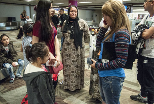 A file photo shows Catholic Charities caseworker Vari Haval on the phone, making last minute arrangements for a family of Kurdish refugees who fled Syria for Turkey before arriving in Nasvhille, Tenn. Caseworkers from Catholic Charities of Tennessee were on hand greet the refugees and offered case management services to them as they resettled in the U.S. (OSV News photo/Theresa Laurence, Tennessee Register)