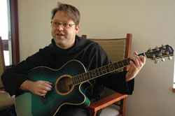 Benedictine Brother Christian Raab plays his guitar on Jan. 2 at Saint Meinrad’s new guest house. He enjoys community prayers, music, Mass, reading and silence, which he describes as “a matter of times and places” in monastic life.