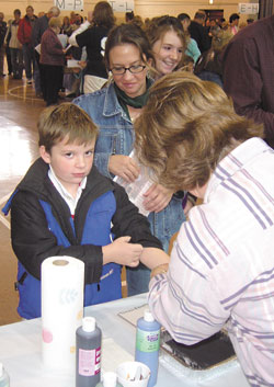 Anthony Treash, a third-grade student at St. Mary School in Greensburg, leaves his “lasting impression” while his mother, Gina, and sister, Sara, wait their turn.