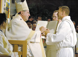 In a gesture symbolic of his promise of obedience, Deacon Rick Nagel places his hands in the hands of Archbishop Daniel M. Buechlein of Indianapolis during a June 2 ordination Mass at SS. Peter and Paul Cathedral in Indianapolis. Deacons Thomas Kovatch and Randall Summers were also ordained during the liturgy. (Photo by Sean Gallagher) 