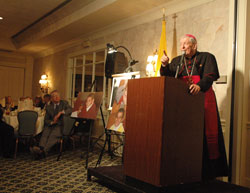 Archbishop Pietro Sambi, apostolic nuncio to the United States, speaks on May 3 at the Meridian Hills Country Club in Indianapolis during a fundraising dinner sponsored by the Franciscan Foundation for the Holy Land. The dinner supported the Franciscan Boys Home in Bethlehem. Photos of the home’s residents are displayed next to Archbishop Sambi. (Photo by Sean Gallagher)