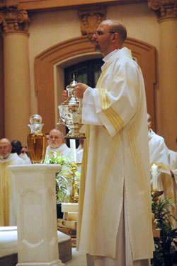 Deacon Jeremy Gries holds an urn containing chrism to be blessed by Archbishop Daniel M. Buechlein during the April 7 archdiocesan chrism Mass celebrated at SS. Peter and Paul Cathedral in Indianapolis. Archbishop Buechlein will anoint the hands of Deacon Gries and deacons John Hollowell and Peter Marshall when he ordains them to the priesthood on June 6 at SS. Peter and Paul Cathedral. (File photo by Sean Gallagher) 