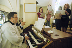 Seminarian Jerry Byrd directs the choir of St. John the Baptist Parish in Osgood during a Nov. 22 Mass at the parish’s church. (Photo by Sean Gallagher)