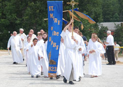 Altar servers, priests and members of St. Mary-of-the-Knobs Parish in Floyd County process to a groundbreaking ceremony on June 27 at the site where the New Albany Deanery faith community’s new church will be constructed. (Submitted photo by Elaine Davis)