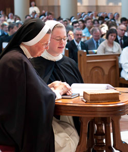 Holding her right hand on a copy of her religious community’s constitutions, Dominican Sister Imelda Grace Lee, right, professes her first vows as a member of the Nashville, Tenn.-based Dominican Sisters of St. Cecilia on July 28, 2011. Holding her hand is Mother Ann Marie Karlovic, superior of the community. The liturgy in which Sister Imelda Grace professed her vows took place in the Cathedral of the Incarnation in Nashville. Sister Imelda Grace is a former member of Christ the King Parish and a graduate of Bishop Chatard High School, both in Indianapolis. (Submitted photo)