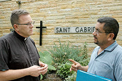Rolando Mendoza Sr. makes a point about the need for immigration reform in the United States to Father Michael O’Mara, pastor of St. Gabriel the Archangel Parish in Indianapolis. The priest and the parishioner both support the Catholic Church’s emphasis that “humane” reform is needed. (Photo by John Shaughnessy)