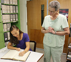 Tracey Horan signs the Sisters of Providence entrance book as Providence Sister Mary Ryan watches. (Submitted photo)