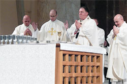 Newly ordained Fathers Andrew Syberg, left, Michael Keucher and Adam Ahern join Archbishop Joseph W. Tobin and concelebrating priests in praying the eucharistic prayer during a June 6 ordination Mass at SS. Peter and Paul Cathedral in Indianapolis. Earlier during the liturgy, Archbishop Tobin ordained the three men to the priesthood. (Photo by Mike Krokos)