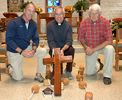 Members of the St. Lawrence School Class of 1961 in Indianapolis gather around a street sign on the parish campus on Sept. 18. Through a school fundraiser auction, class member Betsy Kinne Smith, standing in front of the sign in yellow, won the right to name the sign. On behalf of the class of 1961, she named it for their classmate Lt. Gen. Timothy Maude, the highest ranking officer killed in the Sept. 11, 2001 terrorist attacks. (Photo by Natalie Hoefer)