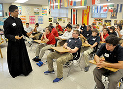 Father Martin Rodriguez, associate pastor of St. Monica Parish in Indianapolis, speaks about his call to the priesthood on Oct. 28 at Roncalli High School in Indianapolis with members of the school’s freshman class. It was part of a day of reflection dedicated to vocations organized by Roncalli’s campus ministry program. (File photo by Sean Gallagher)