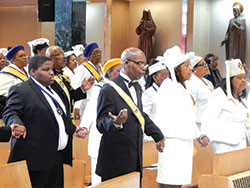 Members of St. Rita Parish’s Knights of Peter Claver and Ladies Auxiliary hold hands while praying the Lord’s Prayer on Oct. 22 during their organizations’ 70th anniversary Mass at St. Rita Church in Indianapolis. (Photo by Mike Krokos)