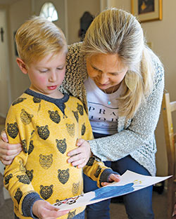 Amy Laddbush examines the artwork crafted by one of her 11 children on March 6 in her Bowie, Md., home. Mother’s Day is on May 12. (CNS photo/Chaz Muth)