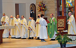 Archbishop Charles C. Thompson serves as principal celebrant at the Miter Society Mass in St. Mary-of-the-Knobs Church in Floyd County on Oct. 21. Concelebrating with him are Fathers William Marks, left, William Ernst, Anthony Hollowell, Stephen Banet, Daniel Atkins, Wilfred “Sonny” Day and Msgr. William F. Stumpf. Altar server Garrett Jennings holds the missal for the archbishop. (Submitted photo by Leslie Lynch)