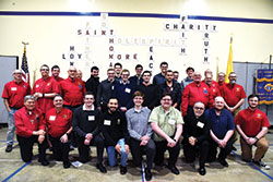 Seminarians from Bishop Simon Bruté College Seminary in Indianapolis, accompanied by Father Joseph Moriarty, the seminary’s rector, pose with members of Saint Thomas More Knights of Columbus Council 7431 after a March 27 dinner to support vocations to the priesthood, diaconate and religious life at St. Thomas More Parish in Mooresville. The Knights organized the dinner. (Photo by Sean Gallagher)