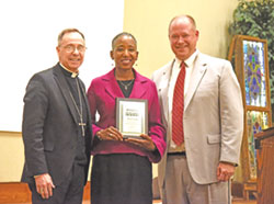 Archbishop Charles C. Thompson and Judge David Certo of the Marion County Superior Court pose on Oct. 2 with Angela Espada, executive director of the Indiana Catholic Conference during a dinner at the Archbishop Edward T. O’Meara Catholic Center in Indianapolis following the annual Red Mass of the St. Thomas More Society of Central Indiana. Espada was honored with the society’s Woman of All Seasons Award. (Photo by Sean Gallagher)