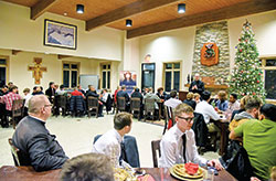 Young men from across the archdiocese listen on Dec. 28 to Father Michael Keucher, archdiocesan vocations director, speak about priestly vocations during the archdiocesan vocations office’s annual St. Andrew Dinner at Bishop Simon Bruté College Seminary in Indianapolis. (Photo by Sean Gallagher)
