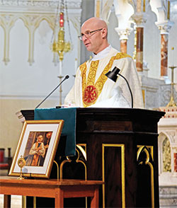 Father Michael Keucher, archdiocesan vocations director, preaches a homily at St. John the Evangelist Church in Indianapolis during a Feb. 9 Mass that was part of the archdiocesan vocations office’s third annual Day of Prayer with St. John Vianney for Priestly Vocations. A relic of the patron saint of priests is displayed in front of the ambo. (Photo by Sean Gallagher)