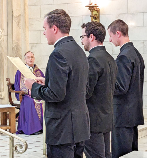 With Archbishop Charles C. Thompson looking on, Deacon Thomas Day, left, Deacon Liam Hosty and Deacon Isaac Siefker make an oath of fidelity to the Church and its shepherds during a Vespers liturgy on March 30 in the Blessed Sacrament Chapel of SS. Peter and Paul Cathedral in Indianapolis. The three transitional deacons will be ordained priests on June 7 in the cathedral. (Photo by Sean Gallagher)