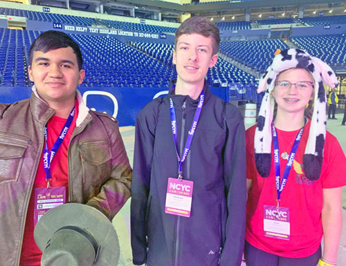 Gabriel Gonzalez of Our Lady of the Greenwood Parish in Greenwood, Ind., shares a photo with Matthew Biehl and Lillie Bischoff, both of St. Gabriel Parish in Connersville, Ind., after Pope Leo XIV shared a digital encounter with more than 15,000 youths at the National Catholic Youth Conference on Nov. 21. (Photo by John Shaughnessy)
