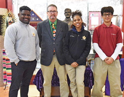 Otto Hernandez, left, John Hegarty, Onoseh Akpeokhai and Miguelangel Flores pose on Dec. 11, 2025, in the lobby of Father Thomas Scecina Memorial High School in Indianapolis. Hernandez is a teacher in the school. Hegarty is its director of international programs. Onoseh and Miguelangel are both juniors at Scecina. (Photo by Sean Gallagher)