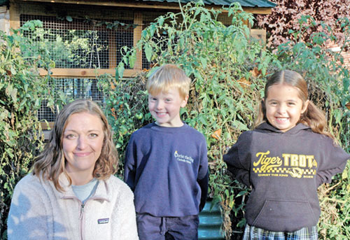 Jackie Chandler, the &ldquo;Garden Lady,&rdquo; helps children, including Marty Funk and Emelia Marshall, understand that everything that happens in the garden at Christ the King School in Indianapolis is rooted in the belief that God provides so much abundance for us in life. (Photo by John Shaughnessy)