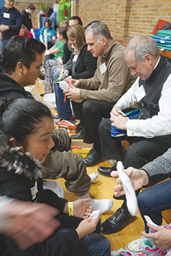 Before their guests were fitted for new shoes, volunteers washed each guest’s feet in an act of humility and kindness, just as Jesus did with the apostles. (Photo by Caroline B. Mooney)